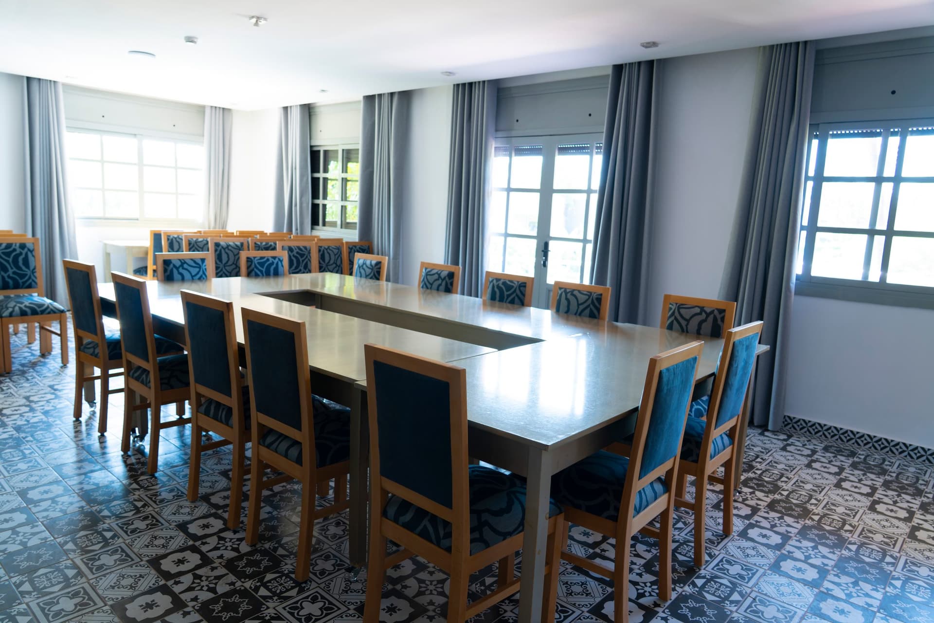 La salle de conférence : une grande table, des chaises bleues