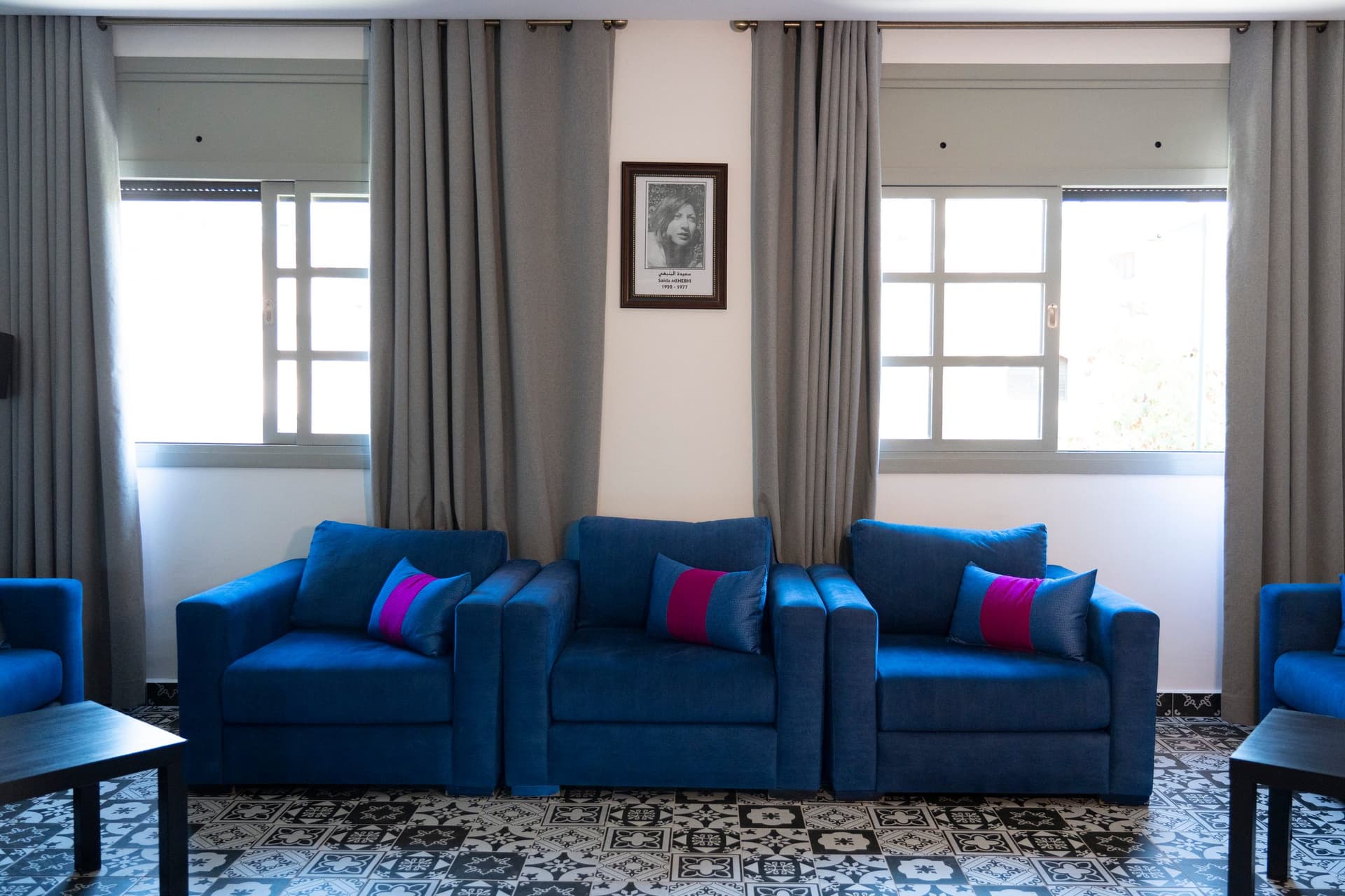 Le salon : fauteuils bleus, et le portrait de Saïda Menebhi entre deux fenêtres
